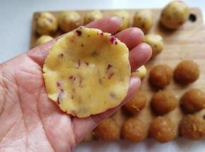 取一份酥皮面团用手心压扁，尽量使其中间厚四周薄点