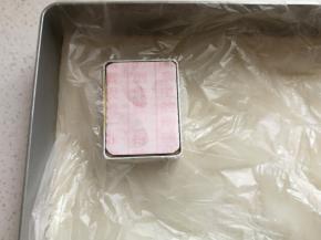 先盖上一小块保鲜膜，再把硬纸卡片放在模具中，双手在四个角稍微用力按压纸片，压好后取下纸片和保鲜膜，一个完美有型的凤梨酥就压好了