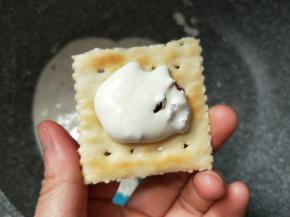 舀一勺棉花糖夹馅放在一片苏打饼干上。