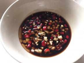 取小碗倒入香醋、麻油、酱油和蒜末小米辣搅拌均匀