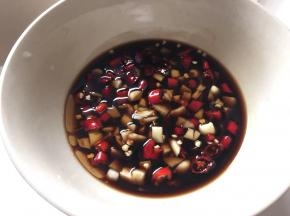 取小碗倒入香醋、麻油、酱油和蒜末小米辣搅拌均匀