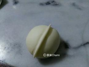 面团包入馅后，整成圆形，中间夹起一条。
