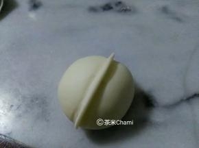 面团包入馅后，整成圆形，中间夹起一条。