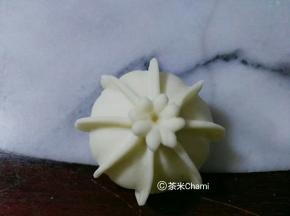 再用面团压出小花。粘在中间，如图。
夏天室温发酵半小时，冬天烤箱30度发酵半小时，蒸十分钟。