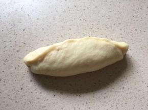 面团由上往下卷起，卷第一卷是将左右两端尽量往内收成橄榄形状，卷好后底部收口要捏紧