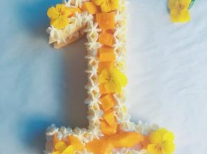 两边挤上奶油 中间铺上芒果粒 再放上几朵小黄花 