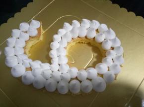 蛋糕胚放蛋糕托上，淡奶油放裱花袋里，用圆形的裱花嘴，将淡奶油像图中这样挤到蛋糕胚上