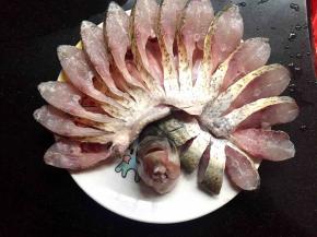 拿一个干净的圆盘，把鱼一瓣瓣的顺着一个方向往左边倒，摆好的形状就像孔雀开屏一样，把头立在中间