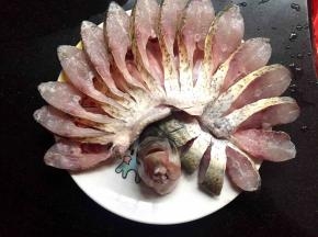 拿一个干净的圆盘，把鱼一瓣瓣的顺着一个方向往左边倒，摆好的形状就像孔雀开屏一样，把头立在中间