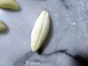 白面团平均分成11个，搓成头尾尖，并用分割板，割一条线，如上图。