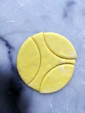 南瓜面团，擀平（不要太薄，4mm左右厚）
用饺子的圆形模，压出三个瓣。