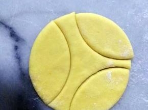 南瓜面团，擀平（不要太薄，4mm左右厚）
用饺子的圆形模，压出三个瓣。