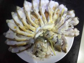 把蒸好的鱼拿出来，倒掉蒸鱼流出来的汤汁，因为这个汤汁比较腥，还有把葱姜蒜用筷子夹掉，是为了美观