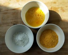 准备三个小碗，其中一个把鸡蛋打散，一个装淀粉，一个装面包糠。