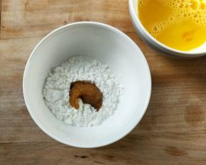 将腌制好的鸡粒先放淀粉碗中滚一圈，用筷子夹起抖一下。