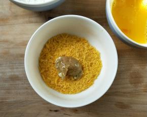 再放面包糠中让鸡粒均匀裹上一层面包糠。