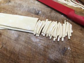 像叠扇子一样叠起来，每折一次之前都要撒干粉，防止切的时候粘连，用刀切成细条，宽窄根据自己喜欢。将切好的面散开并在表面撒少许面粉，这样手擀面就做好了。打开之后，在表面撒少许干粉（用木薯淀粉防粘效果更好）