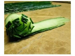 取两片剪好的瓜片，从一端卷起来，不要卷的太松 卷好后的末端要按紧服帖住