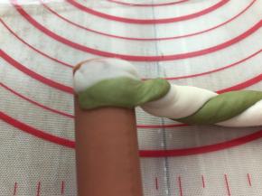 拿面团的一头按压薄，贴在火腿肠上，圈卷在火腿肠上面，收口压在下面。