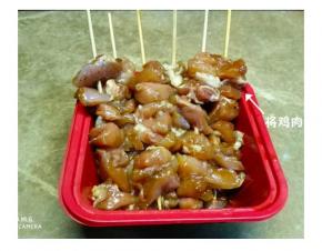 腌好的鸡腿肉用浸泡过的竹签串起来