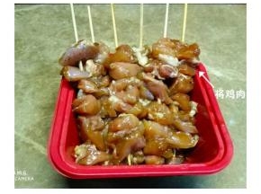 腌好的鸡腿肉用浸泡过的竹签串起来