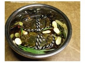 蟹洗刷干净，放入碗中。将葱、花椒、八角、姜、当归、蒜、酒、适量盐全部放入碗中。
