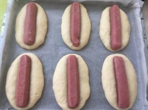 发酵好的面团明显比之前变大，将香肠压在面团中间