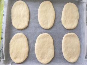 将擀好的面团放烤盘内，盖保鲜膜室温二次发酵