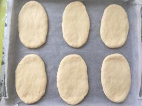 将擀好的面团放烤盘内，盖保鲜膜室温二次发酵