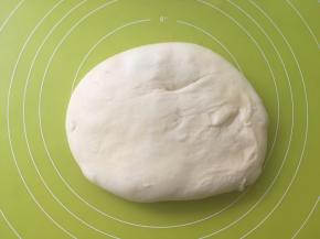 将面团取出放在揉面垫上，按压排气