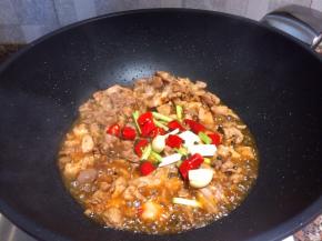 放入辣椒、葱头、大蒜翻炒片刻。