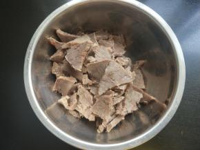 牛肉顺着纹理切片，放入大一点的碗中。