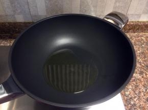 热锅倒油烧至八成热。