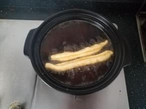 油锅烧热。把油条胚，捏住两头，拉伸至1倍，下油锅。