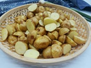 泡好的土豆轻轻搓洗干净，不喜欢吃土豆皮的，可以刮一下，因为是新土豆，用刀或者啤酒盖子轻轻一刮就没有了，小编喜欢吃带皮的，所以直接对半切开就可以，切开煮的快一点，不切的话煮熟以后直接拍扁煎就可以