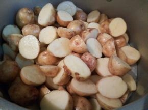 高压锅蒸屉下面加一点水，把对半切好的土豆放高压锅蒸屉上，盖好盖子、开大火、高压锅上汽以后大火继续压3-5分钟，具体看土豆的大小块，土豆大就延长时间