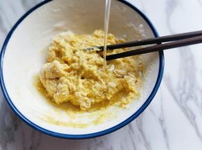 将面粉倒入蛋液中，用手动打蛋器打至均匀且无干粉，加入玉米油。