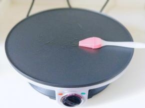 将煎饼机连接电源预热2分钟，刷上一层玉米油。