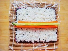 再铺上一层白米饭，白米饭提前加入适量果醋搅拌下，中间放上食材。