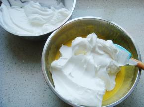 把打好的蛋白分一半倒入蛋黄糊糊里。呈“J”字形翻拌，不可划圈避免消泡。