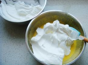 把打好的蛋白分一半倒入蛋黄糊糊里。呈“J”字形翻拌，不可划圈避免消泡。