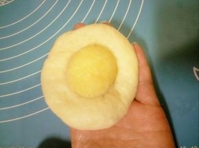 取一个面团压扁，放入一份椰蓉馅。