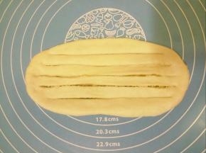 用刀在面团上纵向均匀切5刀，切透，两头不要切断。