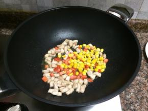 放入胡萝卜和玉米翻炒10秒。