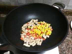 放入胡萝卜和玉米翻炒10秒。