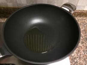 热锅倒油烧至八成热。