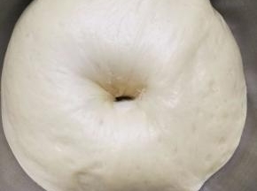 发酵好的面团用擀面仗按压排气，