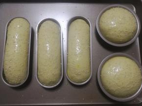 二发好的热狗胚涂上稀释的蛋液，撒上白芝麻装饰。