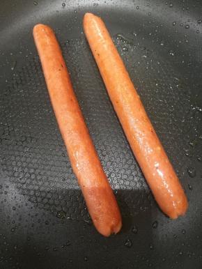 生菜洗净，火腿肠煎一下，西红柿切薄片，将热狗胚竖着或者横着切开，不切断