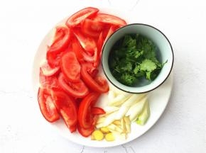 将番茄切成厚度适中的片，大蒜、生姜切片，大葱、香菜切段备用。